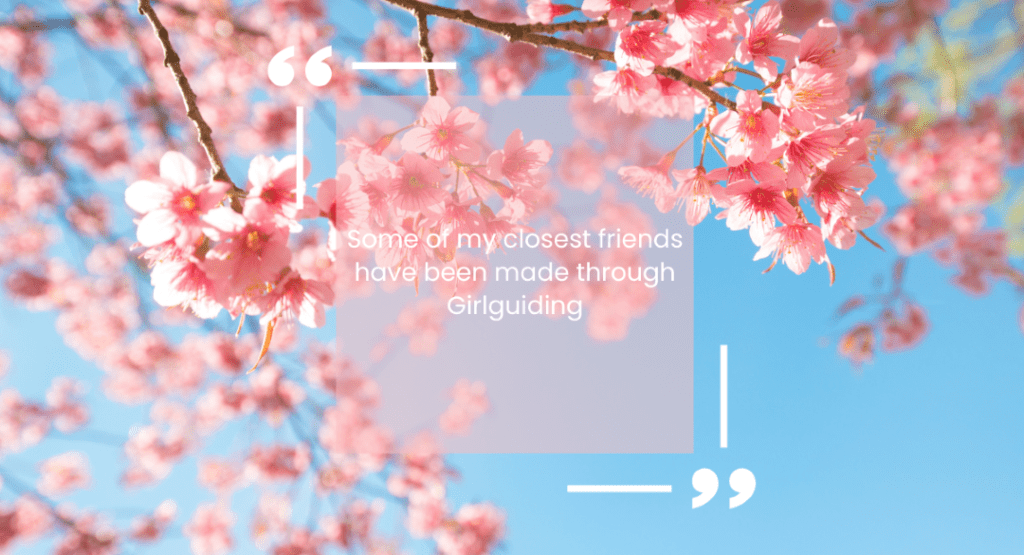 A quote reading "Some of my closest friends have been made through Girlguiding" on a background of blossom with a blue sky.